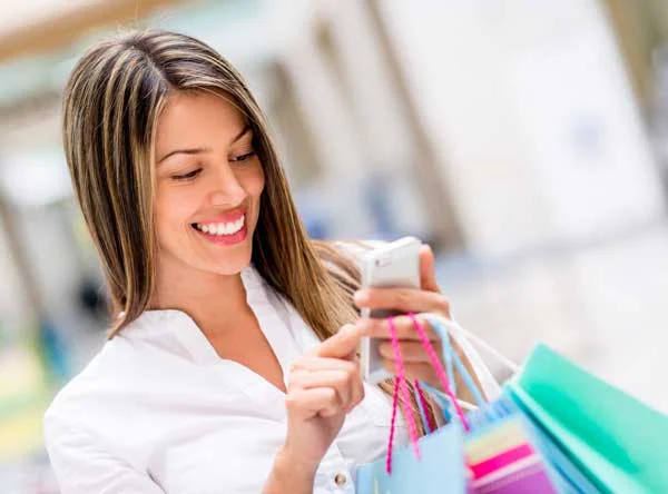 Happy Woman Using Cell Phone at a Shopping Center Happy Woman Using Cell Phone at a Shopping Center